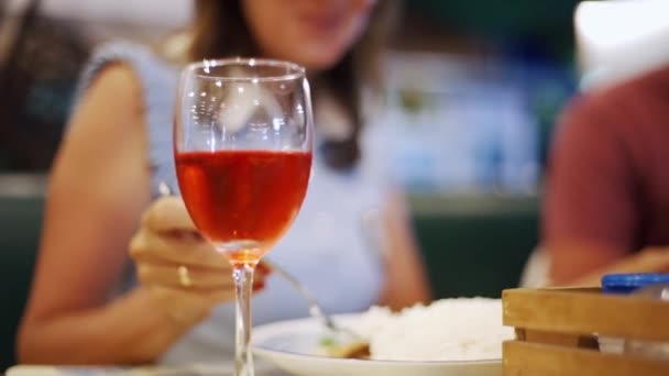 Cuplul ia cina cu un pahar de vin seara rece așezat într-un restaurant cu lumina bokeh pe fundal neclară. Cuplul ia cina cu un pahar de vin — Videoclip de stoc