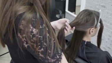 Kuaför kahverengi saçlı bir kız için bir güzellik salonunda laminasyon ve saç düzleştirme yok. saç bakım konsepti