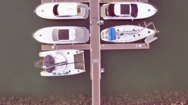 Yat Kulübü ve Marina Drone tarafından Havadan Görünümü. Yat kulübünün en iyi görünümü. Deniz suyunda beyaz tekneler. Marina rıhtım yatlar ve küçük moto. Yat ve yelkenli