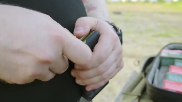 Mans händer lastning en pistol Magazine. man laddar klippet av pistol. — Stockvideo