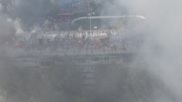 Techo ardiente de un edificio residencial de gran altura, nubes de humo del fuego. Los bomberos apagan el fuego. vista superior — Vídeo de stock