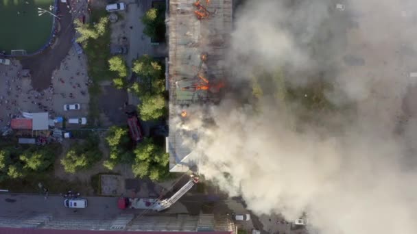 Tetto in fiamme di un grattacielo residenziale, nuvole di fumo dal fuoco. I pompieri spengono il fuoco. vista dall'alto — Video Stock