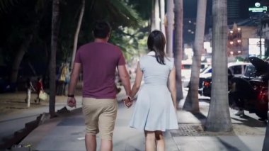 Romantik ve aşk ilişkileri. Genç çift erkek ve kadın Pattaya, Tayland, arka görünümü gece sokakta gezinti boyunca yürüyüş.