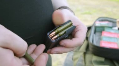 mans eller bir tabanca dergisi yükleme. adam tabanca klibi yükler.