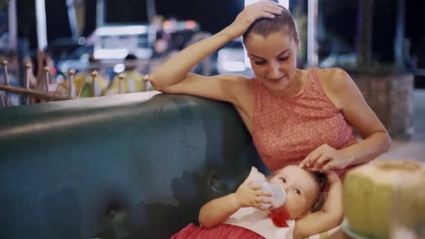 Ευτυχισμένη μαμά ταΐζει την κόρη της με ένα μπουκάλι. — Αρχείο Βίντεο