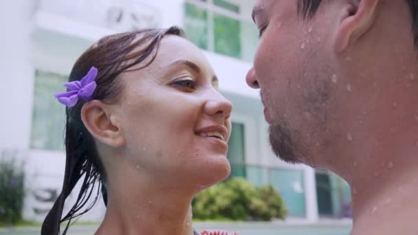 Mannelijke en vrouwelijke kus in water. Mooi paar verliefd man en vrouw in badpakken zwemmen in een zwembad in blauw water. — Stockvideo