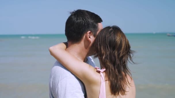 Gelukkige jonge man en vrouw knuffelen op het strand, in de buurt van een boot is vastgebonden, vakantie concept — Stockvideo