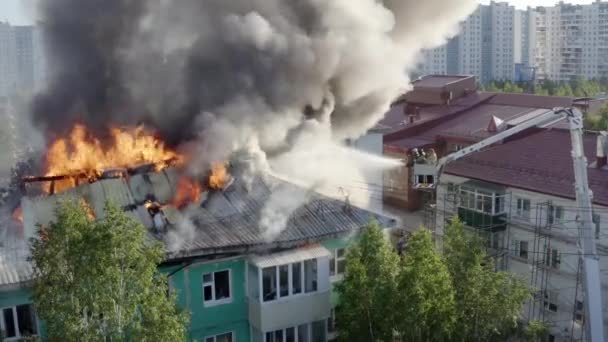 Nizhnevartovsk, Rusland-1 juli 2019: Brandweerlieden blussen een brand op het dak van een residentiële Highrise gebouw. Top View — Stockvideo