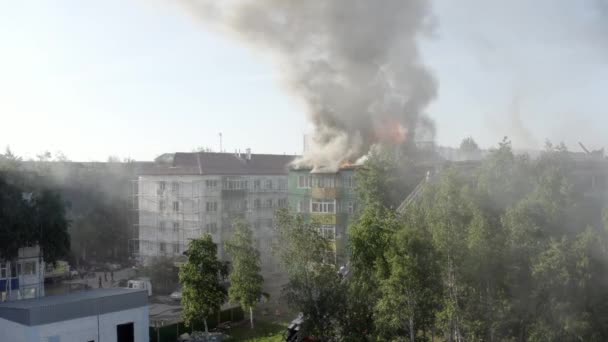 住宅の高層ビルの屋根を燃やし、火事から煙の雲。消防士は火を消した。トップビュー — ストック動画