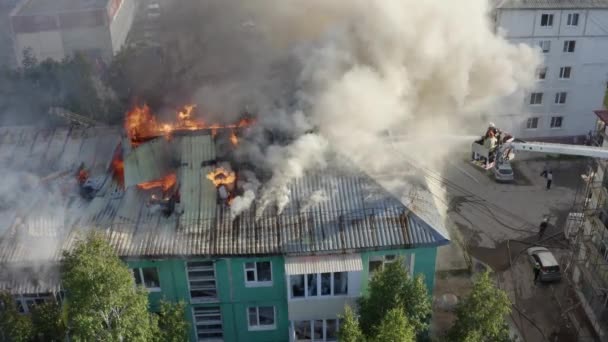 Пожежники гасять пожежу на даху житлового високогірного будинку. вид зверху — стокове відео