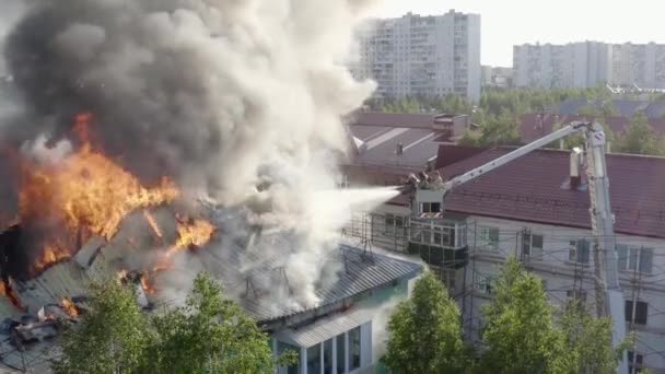 Нижневартовск, Россия - 1 июля 2019 года: пожарные тушат пожар на крыше жилого высотного здания. вид сверху — стоковое видео