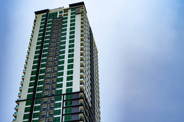 Kurumsal yüksek katlı bina mavi gökyüzü ve bulutlar görülen.