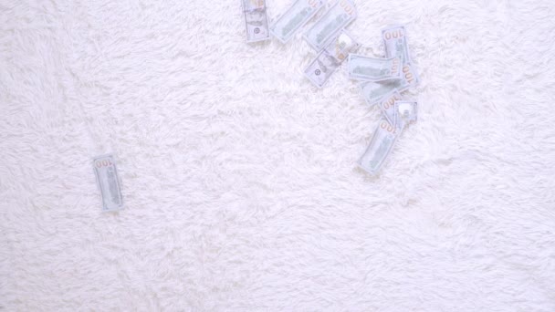 Birçok banknot yavaş çekimde beyaz bir yatakta havada uçar. Büyük para zenginliği, yavaş çekim, üst görünüm — Stok video