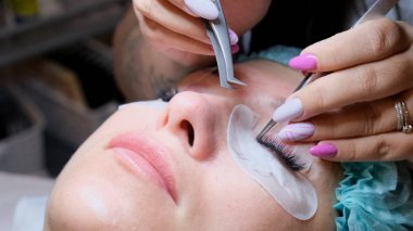 Güzellik salonunda kirpik uzatma prosedürüne tabi tutulan genç bir kadın.