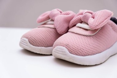 Beyaz arka planda pembe bebek spor ayakkabıları, kopya alanı