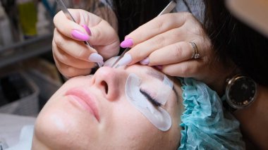 Güzellik salonunda kirpik uzatma prosedürüne tabi tutulan genç bir kadın.