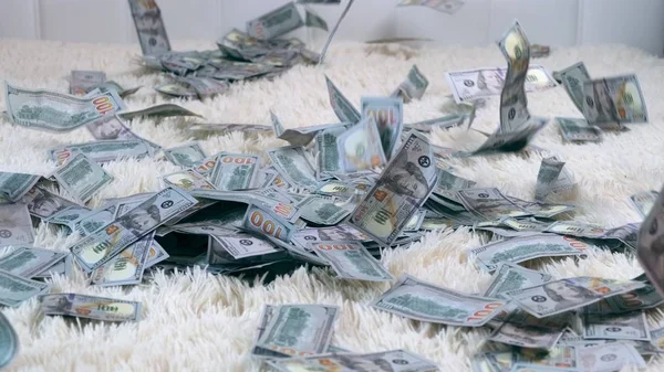 多くの紙幣は、スローモーションで白いベッドの上を空中に飛びます。お金の巨大な富、スローモーション、トップビュー — ストック写真