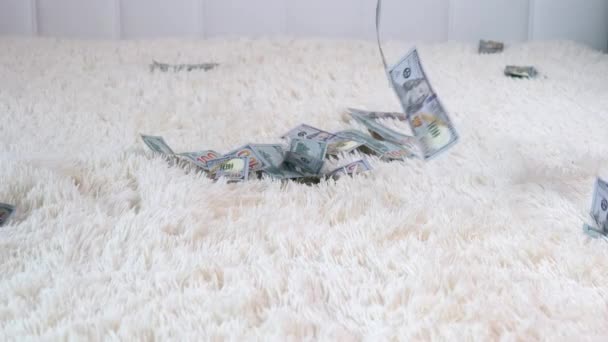 Багато банкнот літають в повітрі на білому ліжку в повільному русі. Величезне багатство грошей, повільний рух — стокове відео