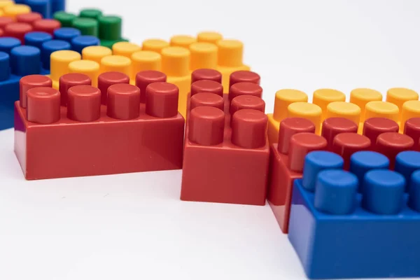 On a white background in a chaotic manner are large multi-colored childrens blocks-designer for the construction of houses and buildings of varying complexity. copy space. — Stock Photo, Image