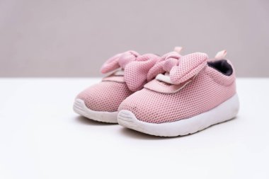 Beyaz arka planda pembe bebek spor ayakkabıları, kopya alanı