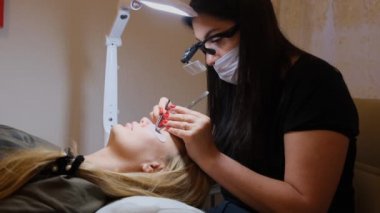 master istemciye büyük kirpikler oluşturur. Güzellik fotoğrafçılığı için hazırlık. Görüntü oluşturma.