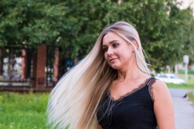 Uzun parlak sarı saçlı genç bir kadının portresi. Saç bakım konsepti.