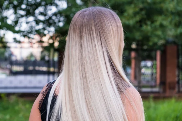 Портрет дівчини з довгим блискучим світлим волоссям. Вид ззаду. Концепція догляду за волоссям . — стокове фото