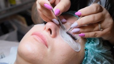 Güzellik salonunda kirpik uzatma prosedürüne tabi tutulan genç bir kadın.