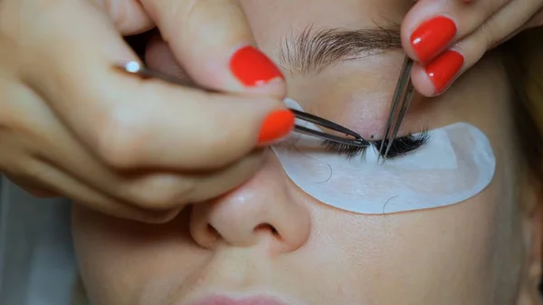 Beautiful Woman with long eyelashes in a beauty salon. Eyelash extension procedure. Lashes close up — Stock Photo, Image