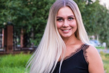 Kameraya bakan uzun parlak sarı saçlı güzel bir genç kadının portresi. Saç bakım konsepti.