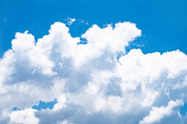 Mavi gökyüzünde süzülen beyaz bulutlar.