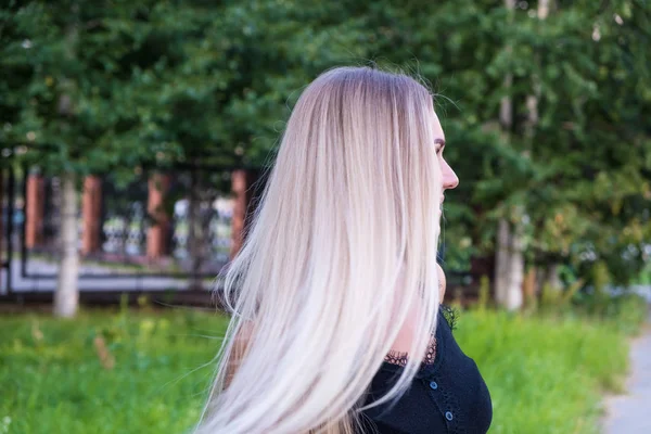 Retrato de una chica con el pelo largo y rubio brillante. Vista trasera. Concepto de cuidado del cabello . — Foto de Stock