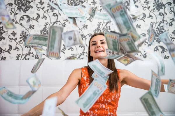 Lot of banknotes fly in the air on a girl lying on a white bed in slow motion. Huge wealth of money — Stock Photo, Image