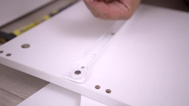 Male hands assembles a cabinet with a screwdriver, close-up. — Stock Video