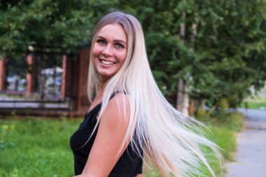 Kameraya bakan uzun parlak sarı saçlı güzel bir genç kadının portresi. Saç bakım konsepti.