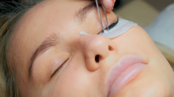 Procedimiento de extracción de pestañas de cerca. Mujer hermosa con pestañas largas en un salón de belleza. Extensión de pestañas. — Foto de Stock