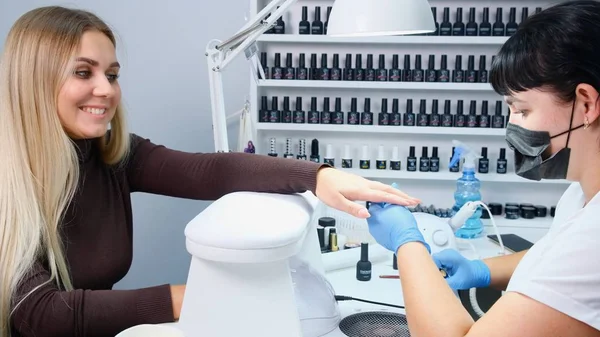 Master aplica el dibujo del barniz a las uñas por el gel en el salón de manicura —  Fotos de Stock