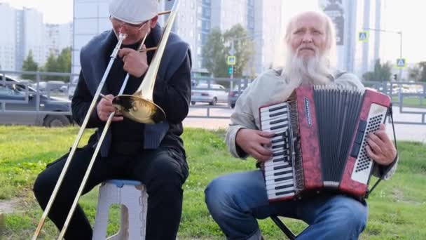 Нижневартовск, Россия - 25 августа 2019 года: уличные музыканты играют на аккордеоне и трубе — стоковое видео