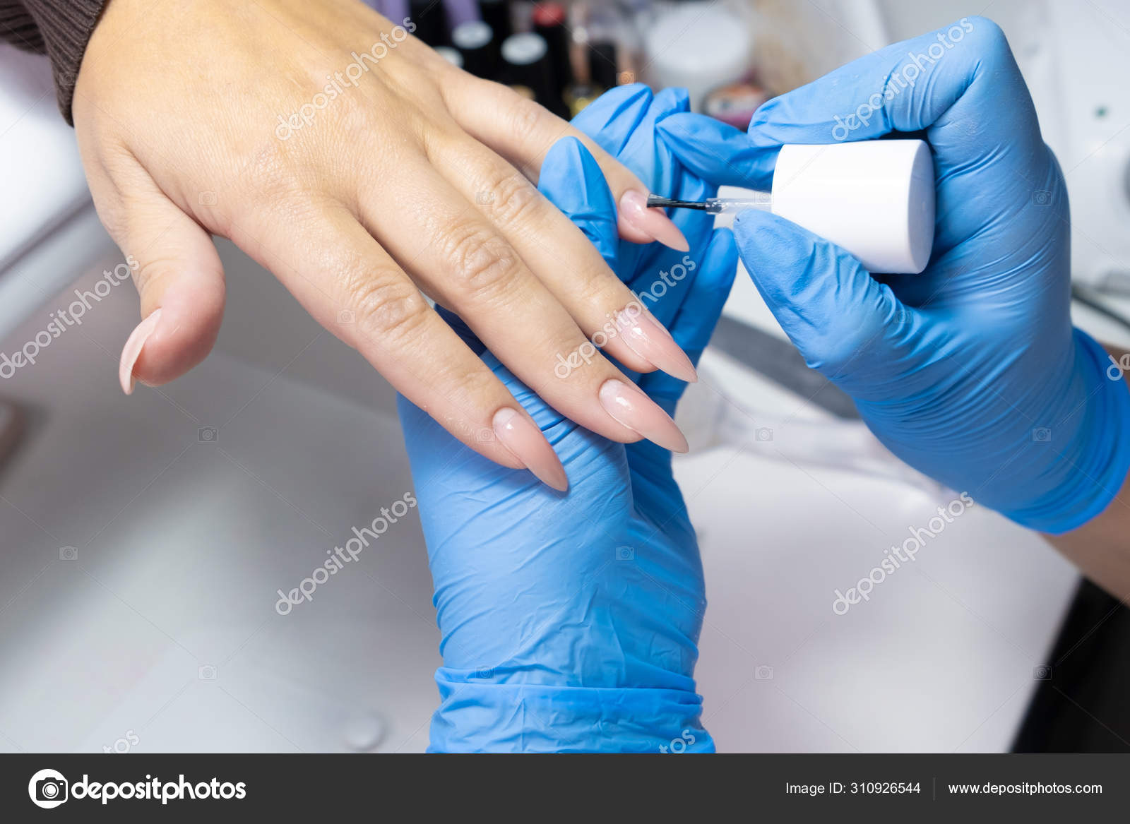 Master applies varnish drawing on nails gel in manicure salon Stock