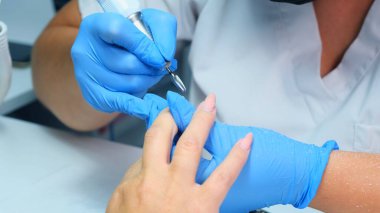 hırdavat manikür. manikürcü güzellik salonunda kadın için donanım manikür yapar. manikür ustası tırnaklarda tırnakları keser. yavaş çekim. hırdavat manikür