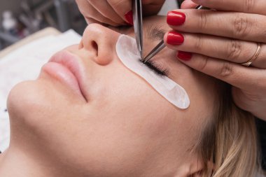 Güzellik salonundaki kirpik uzatma ustasının yapay kirpik uzantıları, tıbbi cımbız hidleri. Yapay kirpik uzantıları Ustasından