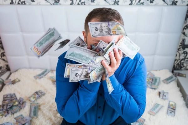 Male holds in his hands a lot of money. and kisses them. A man enjoys a lot of cash dollars. Tremendous wealth concept. — Stock Photo, Image