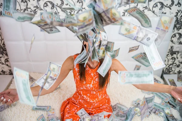 Beautiful girl enjoys tremendous wealth. female throws up a lot of banknotes on a white bed, throws money, top view — Stock Photo, Image