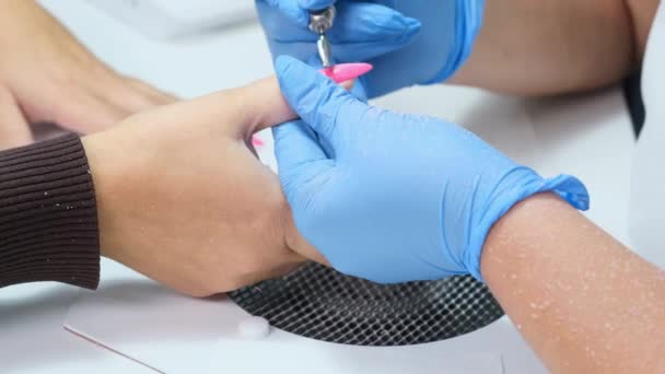 Zamknij drzwi. Elektryczne wiertarki do paznokci w salonie manicure. Manicure sprzętowy w salonie piękności. Manikiurzystka usuwa stary żel z paznokci klientów. Grill ssący. Proces manicure paznokci w salonie piękności. — Wideo stockowe