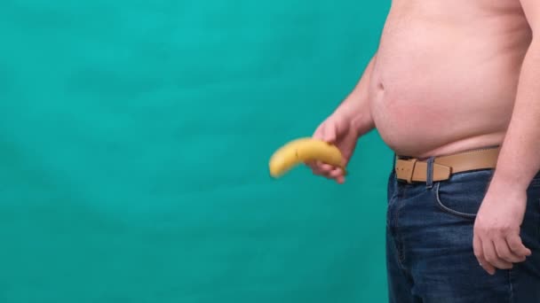 Старий кульгавий банан, що звисає з генітальної зони одягненого невпізнаваного чоловіка, імпотентна еректильна дисфункція або концепція кульгавого члена . — стокове відео