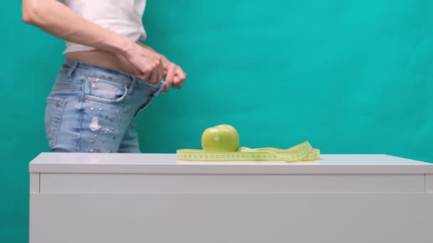 Estómago adelgazado femenino y manzana verde en primer plano, enfoque selectivo. El concepto de pérdida de peso y nutrición adecuada — Vídeo de stock