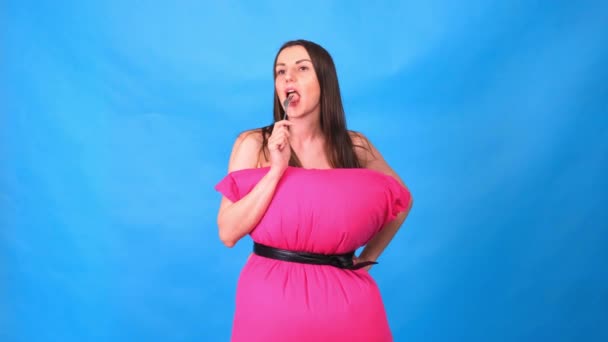 Nejkrásnější dívka v růžových šatech z polštářů je balení vidlička na modrém pozadí. Šílená karanténa. Užijte si lahodné jídlo. Móda 2020. Dej si polštář. Výzva 2020 kvůli domu — Stock video