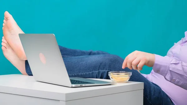 Primo piano di gambe maschili su un desktop vicino a un computer portatile. Il concetto di noia e stanchezza sul lavoro . — Foto Stock