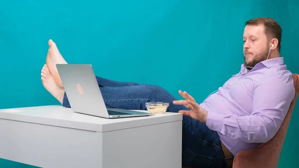 Yakın plan iş adamı iş yerinde tembel ve bacakları masanın üstünde cips yiyor. İşte can sıkıntısı ve yorgunluk kavramı — Stok fotoğraf