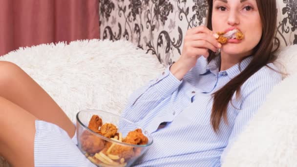 Jeune femme heureuse mangeant du poulet frit, gros plan. Femme mange des ailes de poulet, apport calorique et risques pour la santé, cholestérol — Video